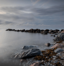 Klippor vid havet under en mulen himmel.