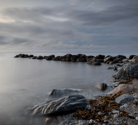 Klippor vid havet under en mulen himmel.